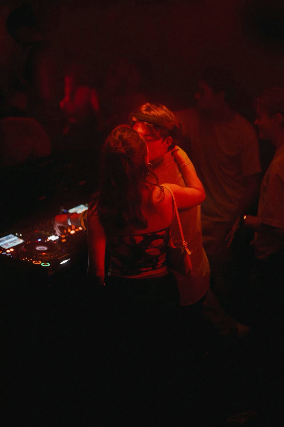 A kiss on a red-lit dance floor