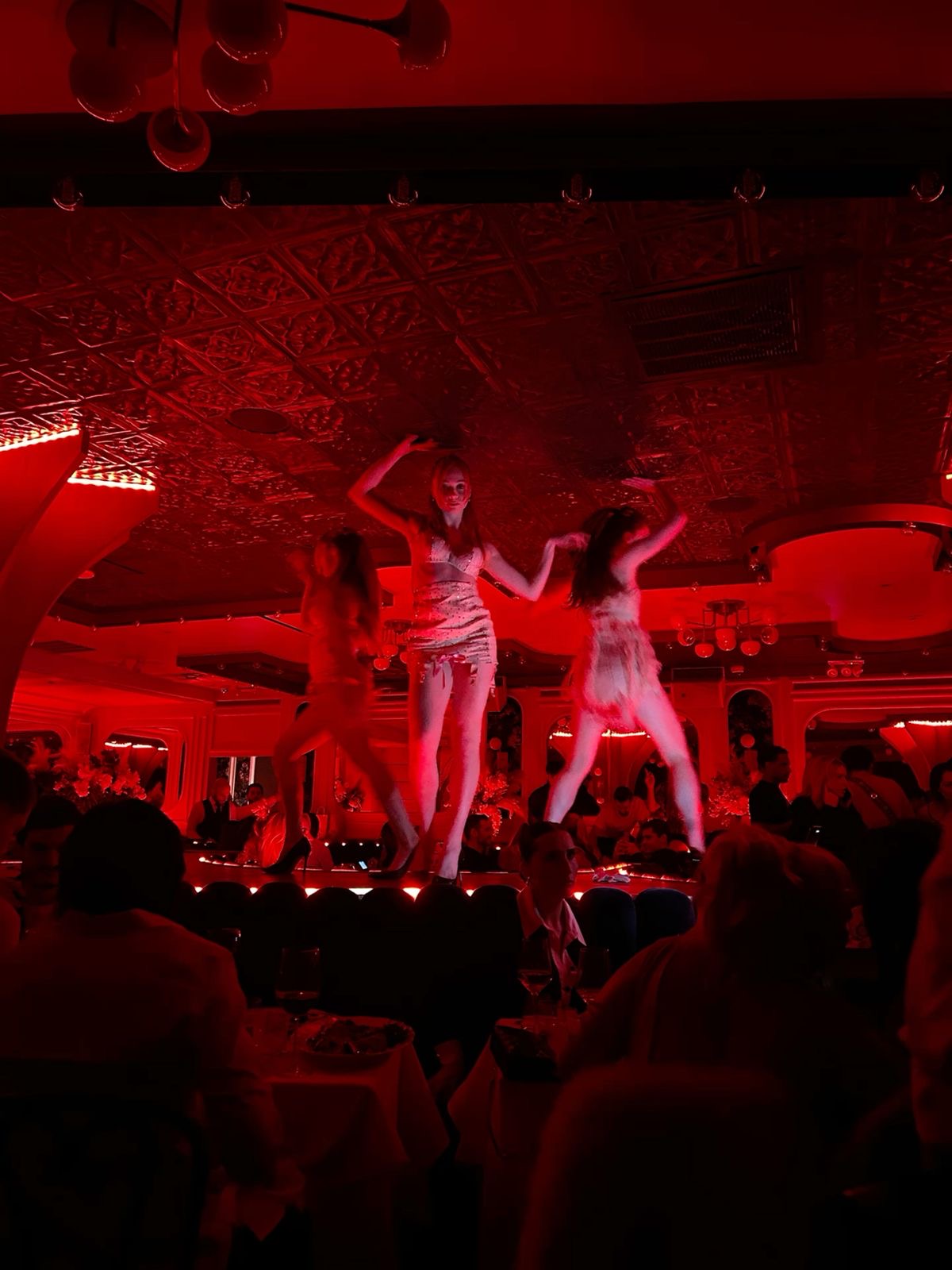 Dancers above the crowd in red light